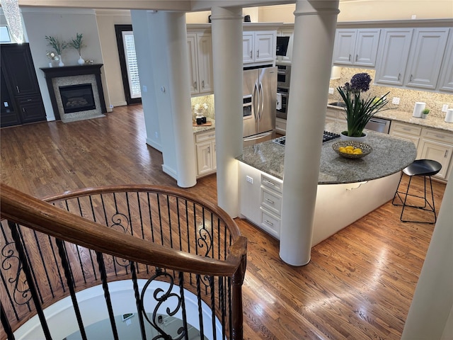 4310 Feagan St Unit A, Houston, TX 77007 - kitchen with decorative columns, appliances with stainless steel finishes, dark wood finished floors, and backsplash