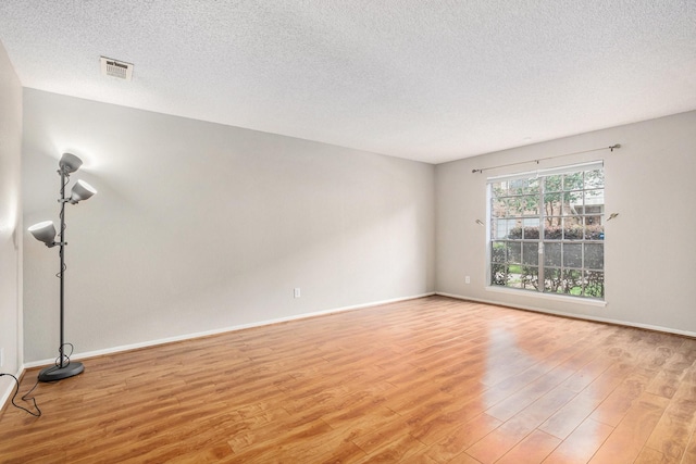 1145 Country Place Dr, Houston, TX 77079 - empty room with light wood finished floors, a textured ceiling, and baseboards