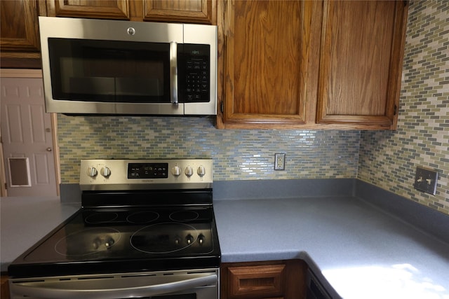 6416 Dawnridge Dr, Houston, TX 77035 - kitchen with stainless steel appliances, backsplash, and brown cabinetry