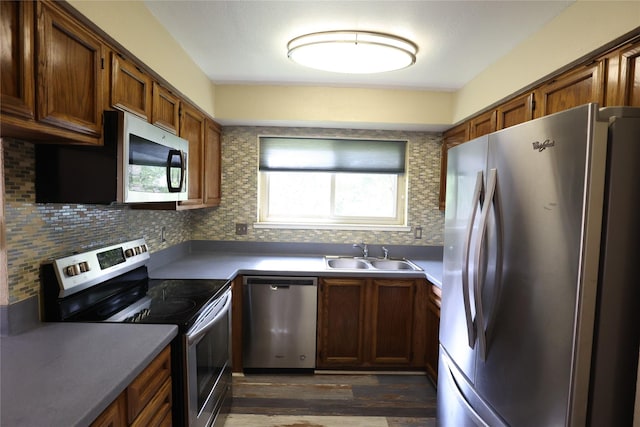 6416 Dawnridge Dr, Houston, TX 77035 - kitchen with appliances with stainless steel finishes, a sink, dark wood-type flooring, brown cabinetry, and backsplash