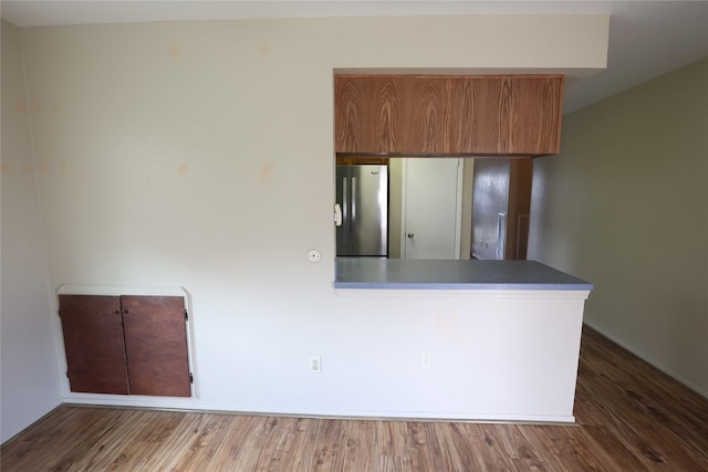 6416 Dawnridge Dr, Houston, TX 77035 - kitchen with freestanding refrigerator, wood finished floors, a peninsula, and brown cabinetry