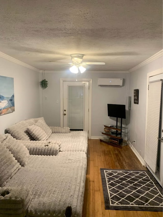 1609 E Bayshore Dr, Dickinson, TX 77539 - bedroom featuring a wall unit AC, wood-type flooring, a textured ceiling, ornamental molding, and baseboards