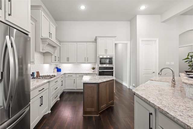 127 Evening Tide Ct, Conroe, TX 77318 - kitchen with appliances with stainless steel finishes, backsplash, dark wood-style floors, white cabinets, and recessed lighting