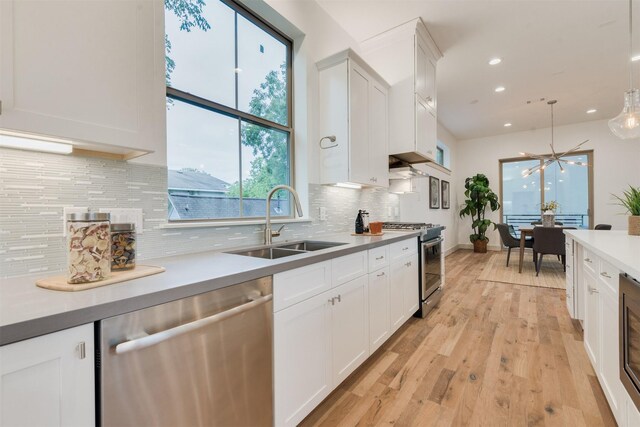 1414 Wichman St, Houston, TX 77007 - kitchen featuring stainless steel appliances, a sink, white cabinets, and recessed lighting