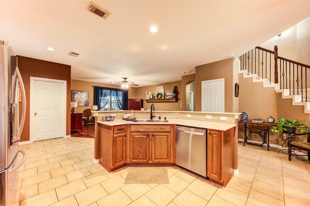 2714 San Marco Ln, League City, TX 77573 - kitchen with stainless steel appliances, a sink, light countertops, a center island with sink, and brown cabinets