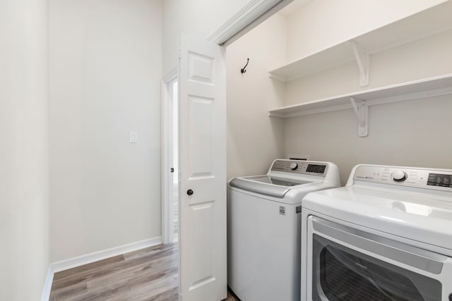15 Prism Cove Pl, The Woodlands, TX 77381 - washroom featuring light wood finished floors, washing machine and clothes dryer, and baseboards