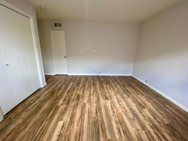 2121 Fountain View Dr Unit 8, Houston, TX 77057 - unfurnished bedroom featuring wood finished floors, baseboards, and a closet