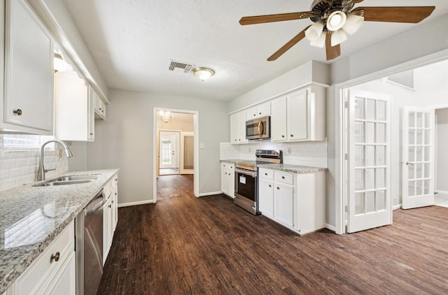 25903 Long Hill Ln, Spring, TX 77373 - kitchen featuring appliances with stainless steel finishes, a sink, decorative backsplash, dark wood-style floors, and baseboards