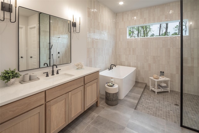 21742 Grayson Highlands Way, Porter Heights, TX 77365 - full bath with a freestanding bath, vanity, tile patterned flooring, tile walls, and tiled shower