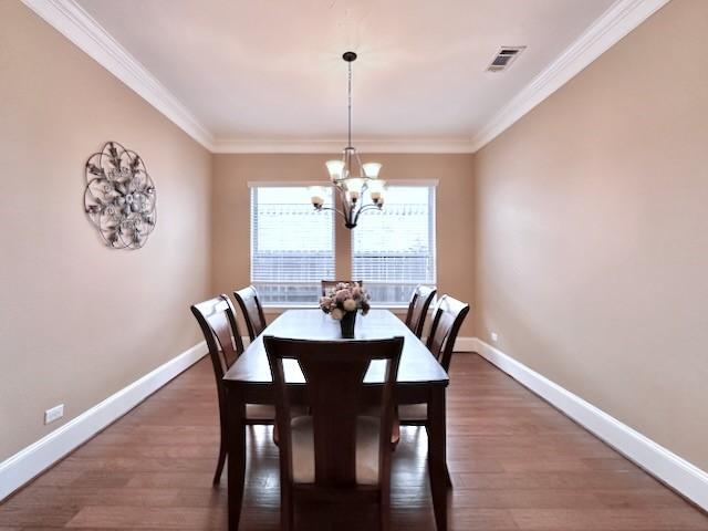 10410 Hatcher Dr, Katy, TX 77494 - dining space with a chandelier, baseboards, crown molding, and wood finished floors