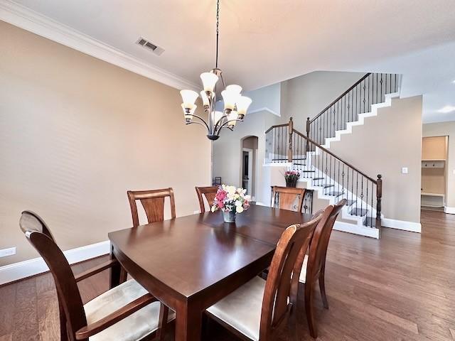 10410 Hatcher Dr, Katy, TX 77494 - dining area featuring wood finished floors, baseboards, stairway, a chandelier, and arched walkways