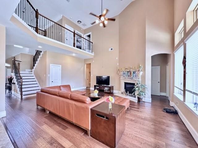 10410 Hatcher Dr, Katy, TX 77494 - living room featuring a towering ceiling, wood finished floors, a fireplace, baseboards, and stairs