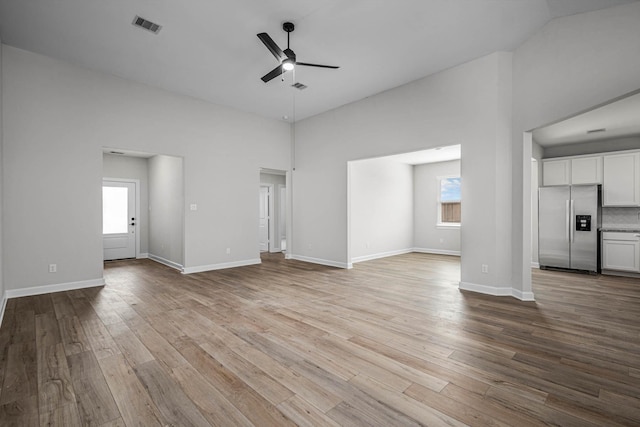 14002 Starboard Reach Dr, Texas City, TX 77510 - unfurnished living room with ceiling fan, wood finished floors, a high ceiling, and baseboards