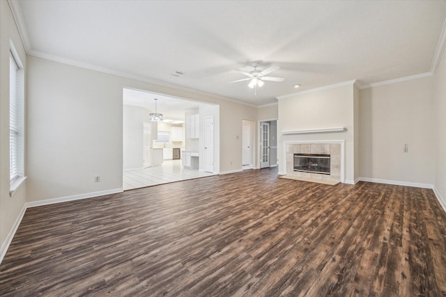 16403 Wellers Way, Houston, TX 77095 - unfurnished living room featuring dark wood finished floors, baseboards, ceiling fan, a tiled fireplace, and ornamental molding