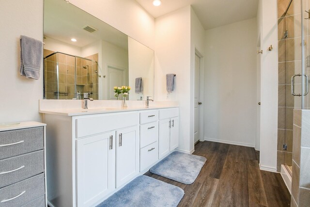 12324 Carib Crossing Ln, Conroe, TX 77304 - bathroom featuring a shower stall, wood finished floors, double vanity, baseboards, and recessed lighting