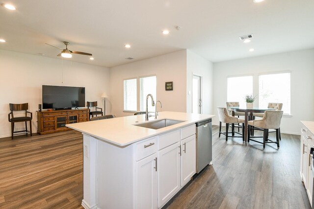 12324 Carib Crossing Ln, Conroe, TX 77304 - kitchen with a sink, stainless steel dishwasher, dark wood finished floors, ceiling fan, and white cabinetry