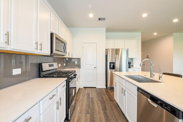 12324 Carib Crossing Ln, Conroe, TX 77304 - kitchen featuring stainless steel appliances, a sink, recessed lighting, dark wood-type flooring, and white cabinetry