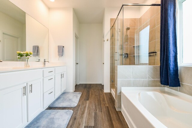 12324 Carib Crossing Ln, Conroe, TX 77304 - full bath with a garden tub, double vanity, a shower stall, wood finished floors, and baseboards