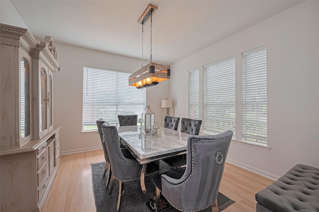 211 Aberdeen St, Stafford, TX 77477 - dining space with healthy amount of natural light, light wood-style flooring, and a chandelier
