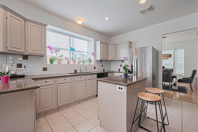 211 Aberdeen St, Stafford, TX 77477 - kitchen featuring stainless steel refrigerator with ice dispenser, healthy amount of natural light, a breakfast bar, light tile patterned flooring, and recessed lighting