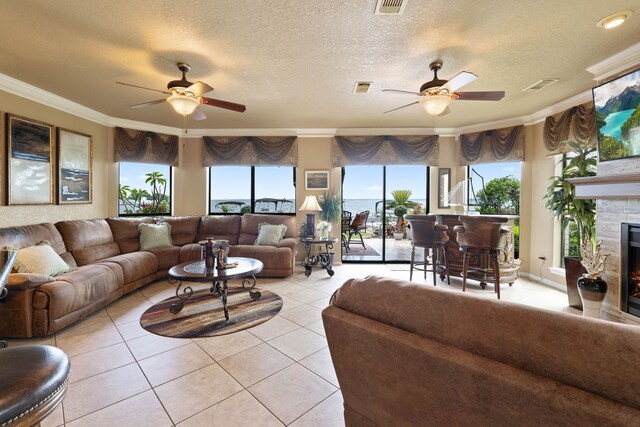 2117 Gunwale Cir, Willis, TX 77318 - living area with a ceiling fan, ornamental molding, healthy amount of natural light, light tile patterned floors, and a textured ceiling
