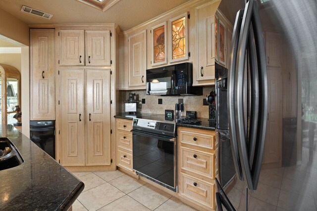 2117 Gunwale Cir, Willis, TX 77318 - kitchen featuring black appliances, light tile patterned floors, backsplash, arched walkways, and dark stone countertops