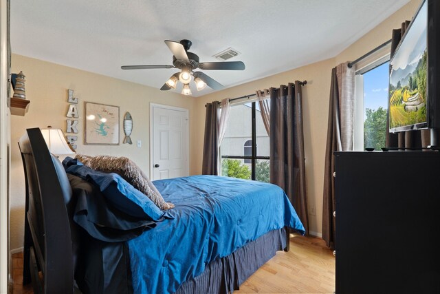 2117 Gunwale Cir, Willis, TX 77318 - bedroom featuring light wood-style floors, multiple windows, a ceiling fan, and baseboards