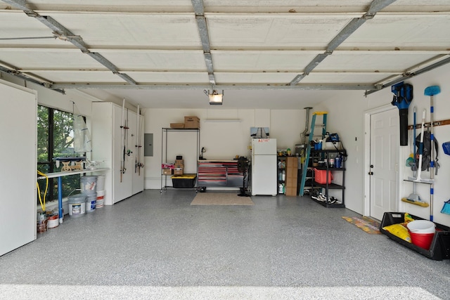 2117 Gunwale Cir, Willis, TX 77318 - garage featuring freestanding refrigerator, a garage door opener, and electric panel