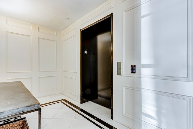 2221 Welch St Unit 601, Houston, TX 77019 - hallway with light tile patterned flooring, elevator, and inlaid floor details