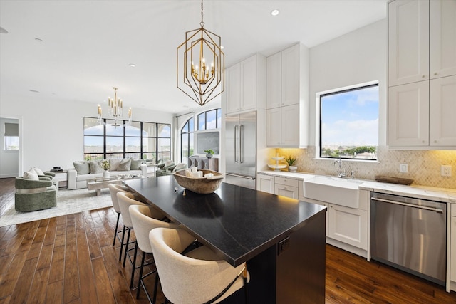 2221 Welch St Unit 601, Houston, TX 77019 - kitchen featuring appliances with stainless steel finishes, a chandelier, dark wood finished floors, a sink, and backsplash