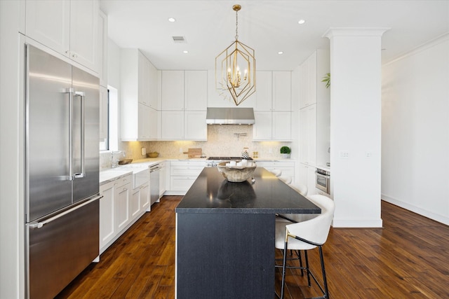 2221 Welch St Unit 601, Houston, TX 77019 - kitchen featuring appliances with stainless steel finishes, a chandelier, ventilation hood, dark wood finished floors, and recessed lighting