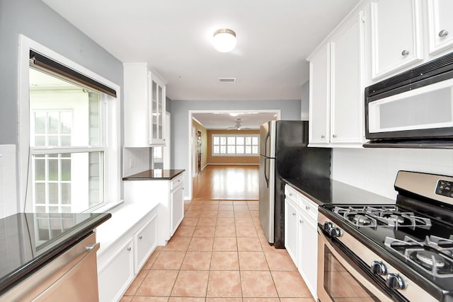 1831 Watercrest Dr, Houston, TX 77008 - kitchen featuring stainless steel appliances, dark countertops, and white cabinetry