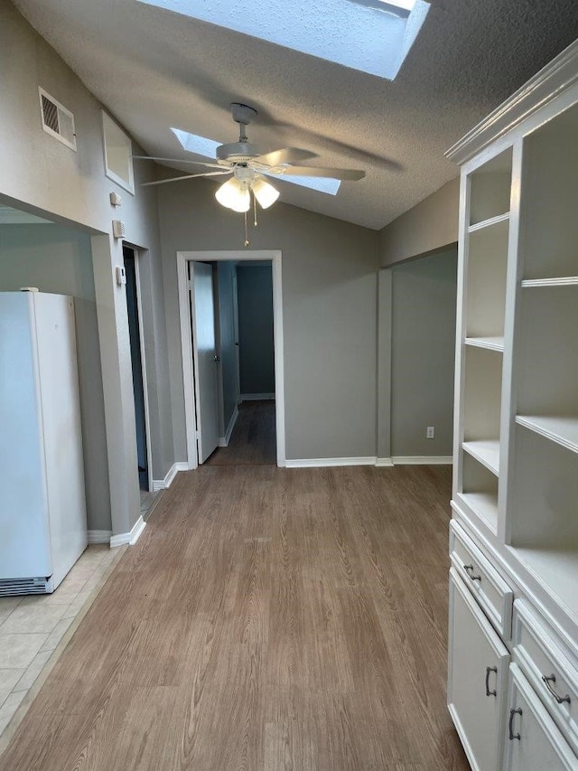 5311 Gano St, Houston, TX 77009 - unfurnished room featuring a skylight, ceiling fan, wood finished floors, a textured ceiling, and baseboards