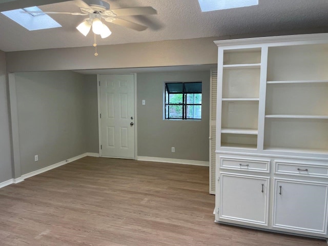 5311 Gano St, Houston, TX 77009 - foyer featuring a skylight, baseboards, light wood-style floors, and a ceiling fan
