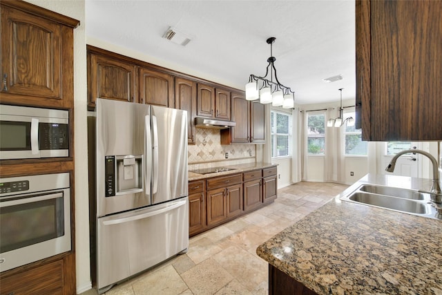 3006 Nickleby Ct, Katy, TX 77494 - kitchen featuring appliances with stainless steel finishes, a sink, under cabinet range hood, stone tile flooring, and backsplash