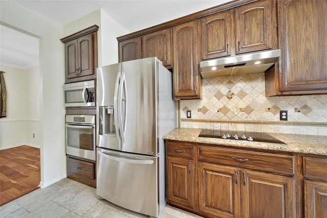 3006 Nickleby Ct, Katy, TX 77494 - kitchen with appliances with stainless steel finishes, under cabinet range hood, decorative backsplash, light stone counters, and crown molding