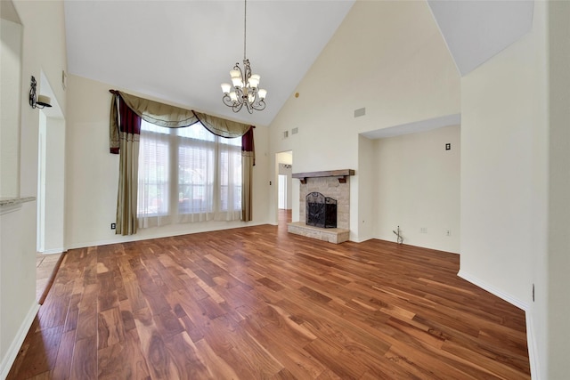 3006 Nickleby Ct, Katy, TX 77494 - unfurnished living room with wood finished floors, a chandelier, a stone fireplace, high vaulted ceiling, and baseboards