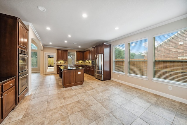 6014 Shady Birch Holw, Houston, TX 77345 - kitchen with ornamental molding, stainless steel appliances, a kitchen island, baseboards, and decorative backsplash
