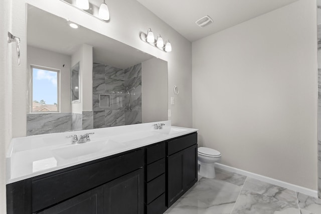 15739 Cairnwell Bend Dr, Humble, TX 77346 - bathroom with double vanity, marble look tiles, a marble finish shower, toilet, and baseboards
