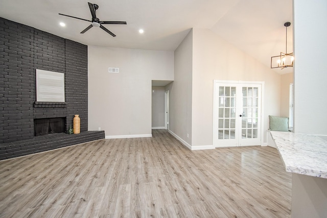 2012 Hickory Glen Dr, Missouri City, TX 77489 - unfurnished living room with a ceiling fan, light wood-style floors, a brick fireplace, a chandelier, and high vaulted ceiling