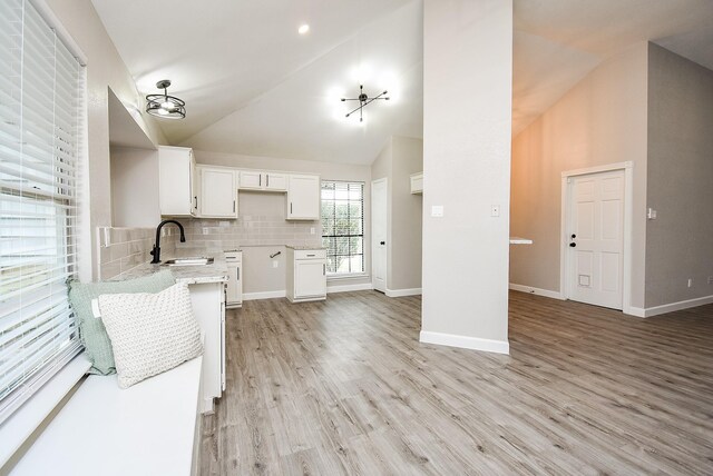 2012 Hickory Glen Dr, Missouri City, TX 77489 - kitchen featuring a sink, high vaulted ceiling, white cabinets, decorative backsplash, and light wood-style flooring