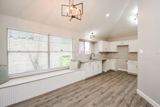 2012 Hickory Glen Dr, Missouri City, TX 77489 - kitchen with a sink, vaulted ceiling, white cabinets, tasteful backsplash, and light wood-style floors