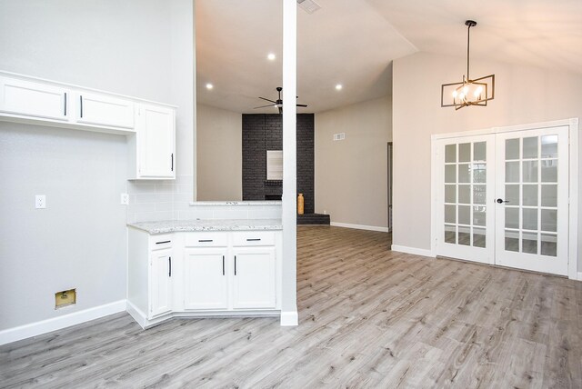 2012 Hickory Glen Dr, Missouri City, TX 77489 - kitchen featuring white cabinetry, decorative backsplash, light wood finished floors, a chandelier, and lofted ceiling