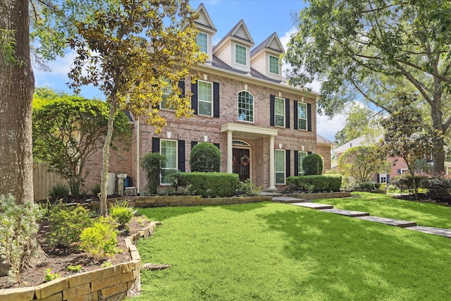 1615 Lake Wilderness Ln, Kingwood, TX 77345 - colonial home with brick siding and a front lawn
