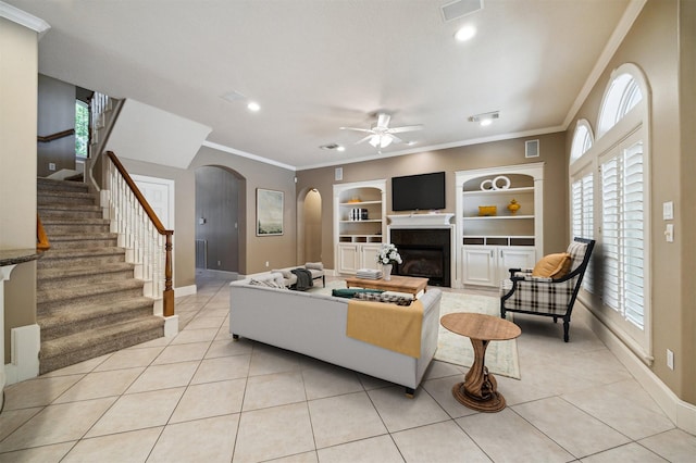 1615 Lake Wilderness Ln, Kingwood, TX 77345 - living area with arched walkways, ceiling fan, light tile patterned floors, baseboards, and crown molding