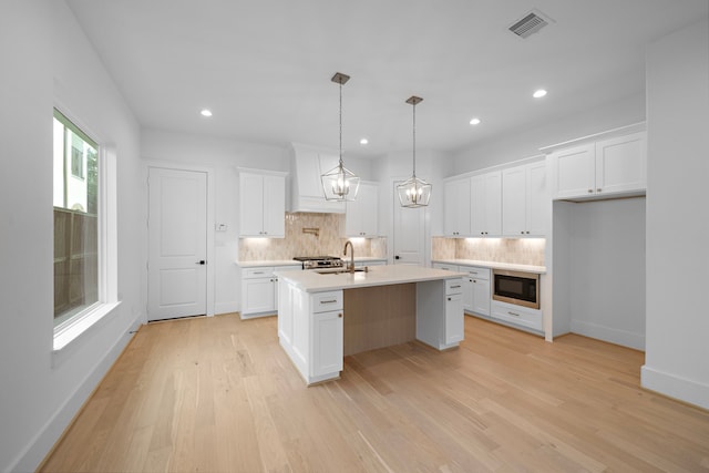 224 W 23rd St Unit B, Houston, TX 77008 - kitchen with tasteful backsplash, black microwave, a sink, light countertops, and premium range hood