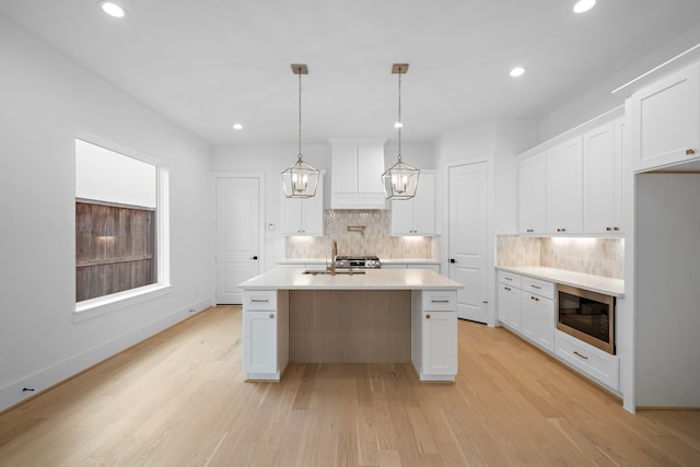 224 W 23rd St Unit B, Houston, TX 77008 - kitchen with stainless steel microwave, backsplash, light countertops, recessed lighting, and light wood-style flooring