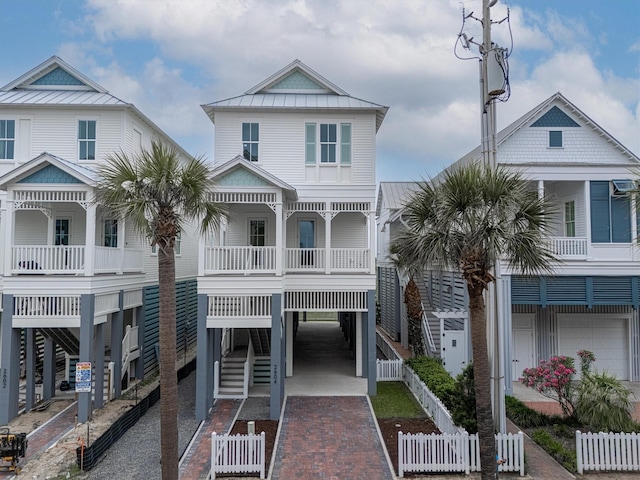 2604 E Seaside Dr, Galveston, TX 77550 - beach home featuring a carport, a standing seam roof, decorative driveway, metal roof, and a balcony