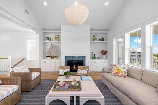 2604 E Seaside Dr, Galveston, TX 77550 - living room with lofted ceiling, a lit fireplace, built in shelves, recessed lighting, and dark wood-style floors
