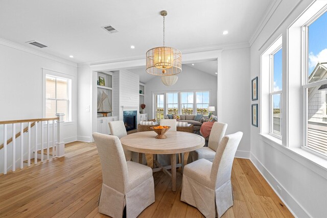 2604 E Seaside Dr, Galveston, TX 77550 - dining room featuring light wood-style flooring, a chandelier, plenty of natural light, crown molding, and recessed lighting